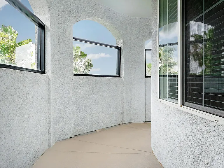 Curved Outdoor Hallway with Arched Windows and Stucco Walls