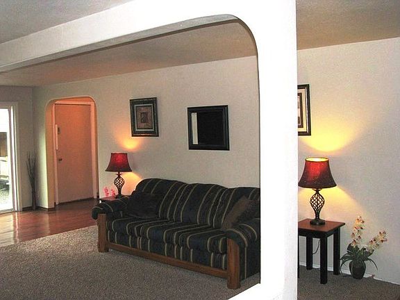 View of living room from entry.  Adjacent sliding glass door gives access to the wrap-around deck;  also, hallway leads to guest bath and kitchen.