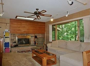 Wood-burning fireplace with unique surround and skylight are the main focal points of this main floor family room!