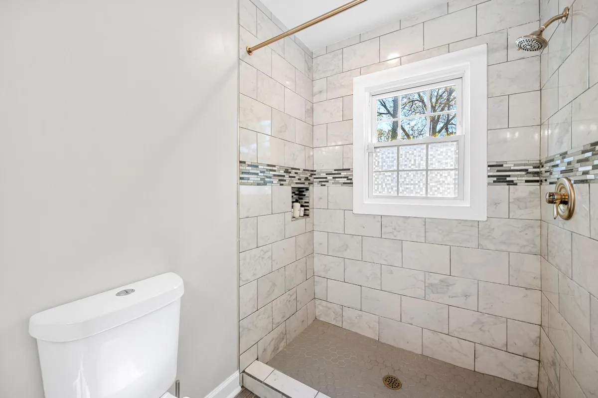 Nestled within the master bedroom is a private bathroom offering a stand-up shower with a charming window, and natural light. - 1826 Chapman Ave