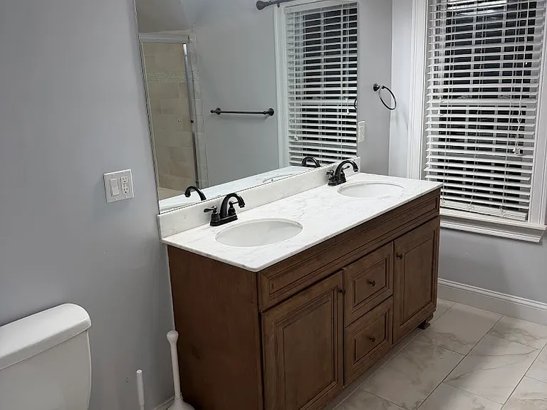 Primary bathroom with double sink vanity and shower/tub.