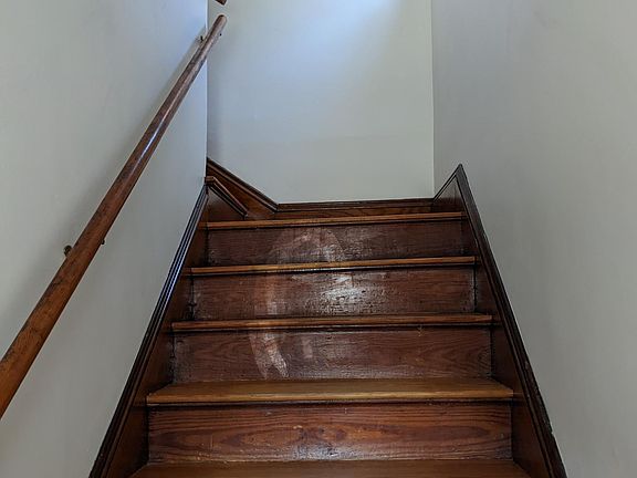 Wooden stairs leading up to 2nd floor, where apartment is located
