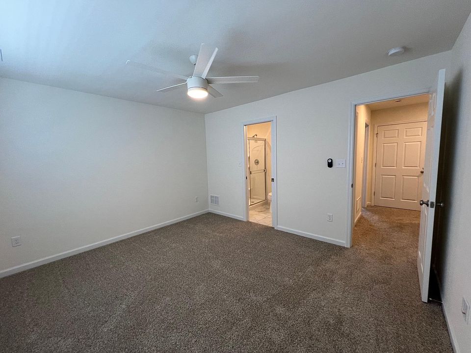 Primary suite with direct access to bathroom, ceiling fan and walk-in closet.