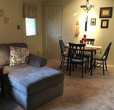 Dining area at end of living room showing newer front door and guest closet