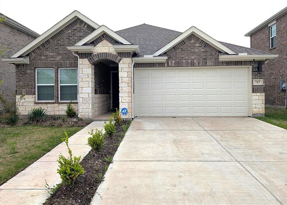 View of front of house with a garage, roof with shingles, driveway, and stone siding