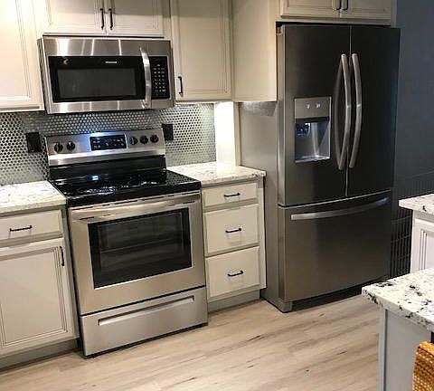 KITCHEN WITH PLANK FLOORING, RANGE AND FRIDGE