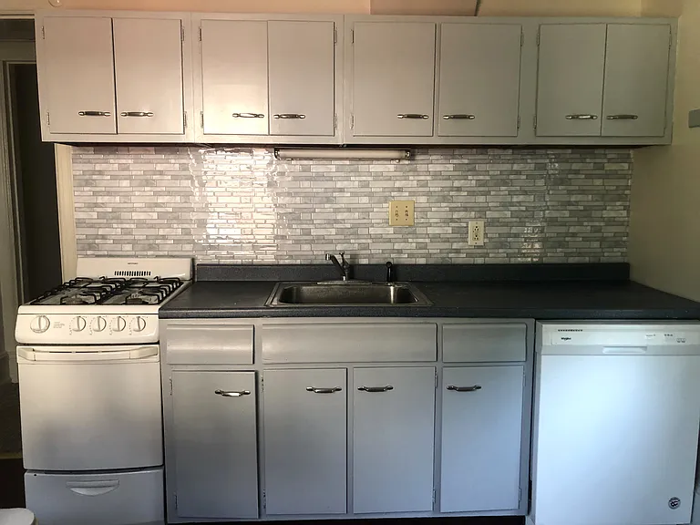 Large updated kitchen with dishwasher and two large windows.