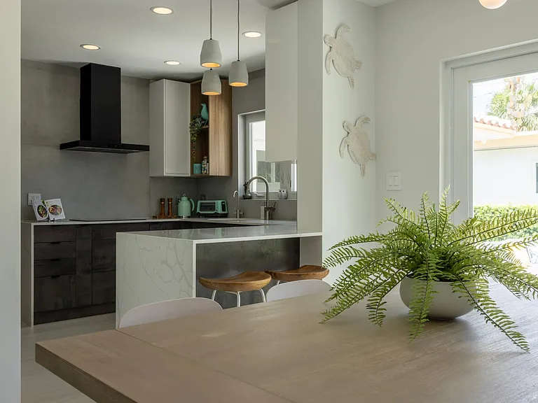 High-end kitchen with bar table, BESPOKE Samsung fridge, GE new appliances, induction stove. Fully equipped with cooking utensils, cookware, dinnerware. View from dining zone.