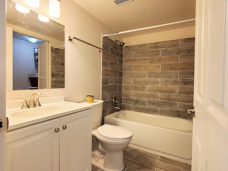 Custom tile on floor and tub surround, new vanity and toilet!
