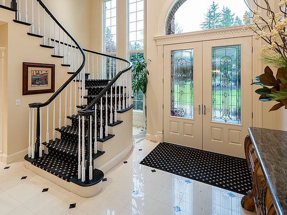 Grand entry with dramatic winding staircase and architectural details.