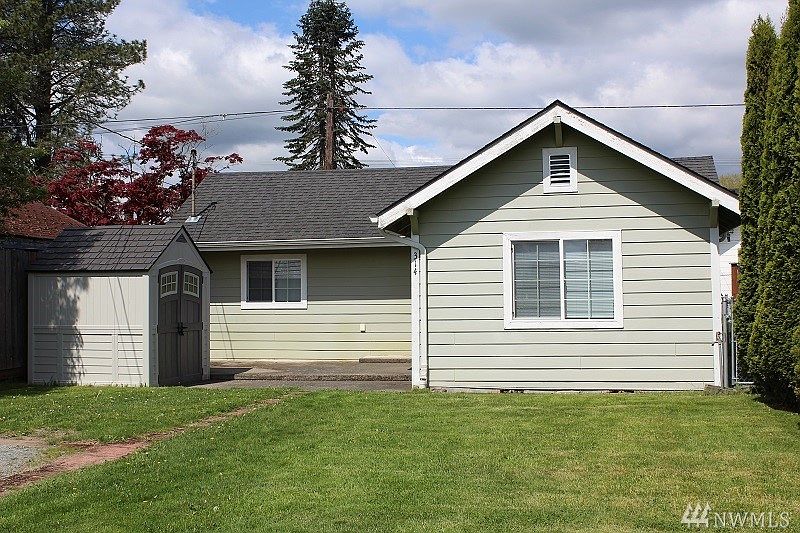 Front of home with patio and storage unit