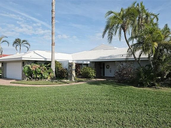 Exterior front with large front lawn and tropical palms