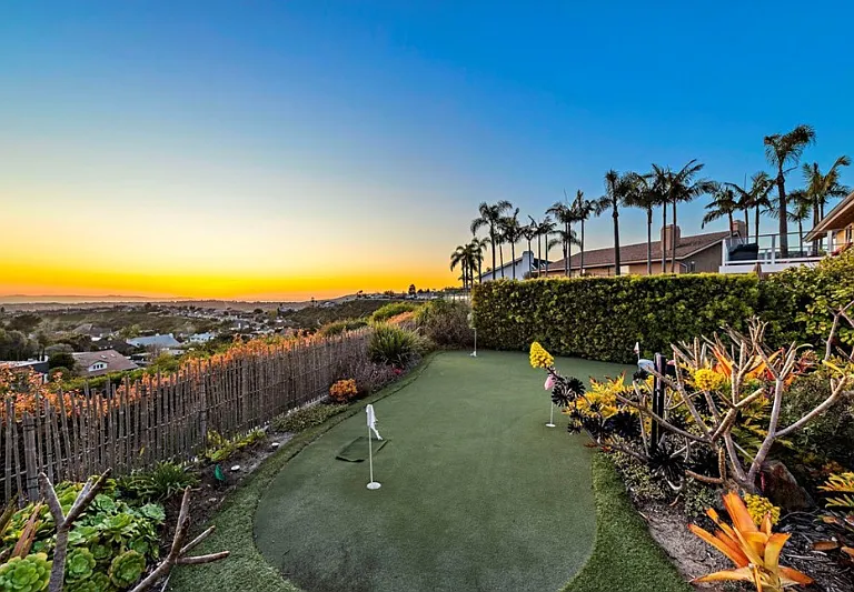 Private backyard putting green surrounded by coastal landscaping_perfect for a little leisure at home.