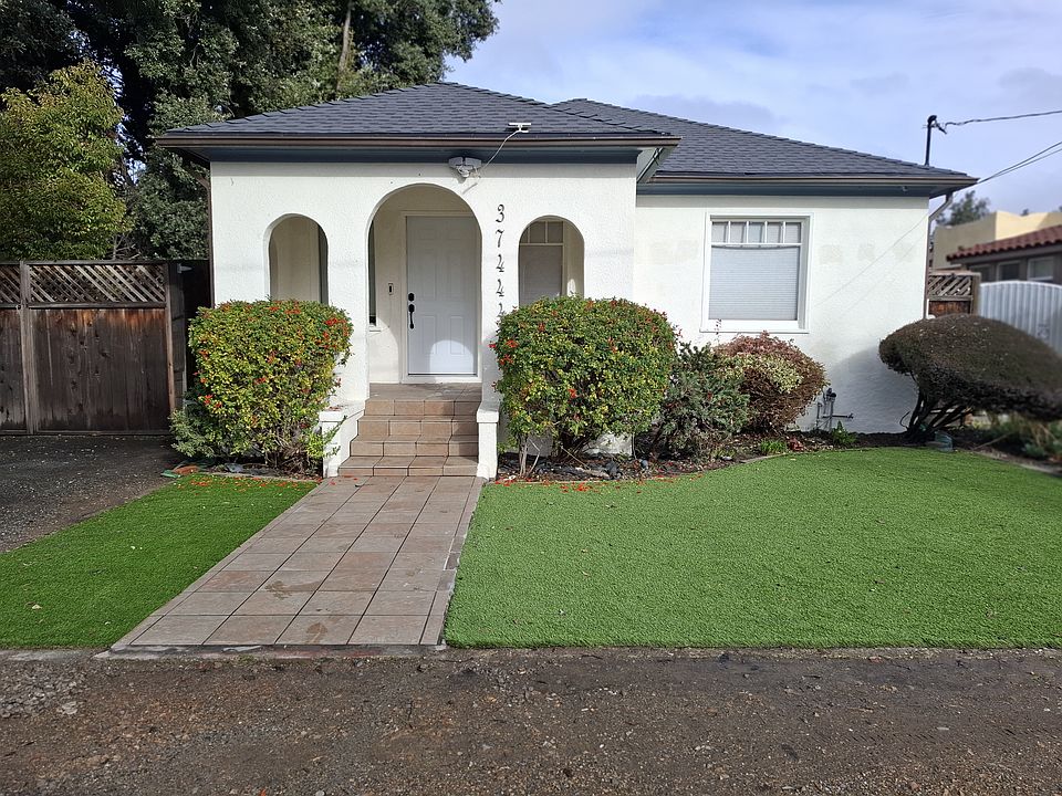 Front of the house with drive-way on the left (off-street parking). New synthetic lawn (low maintenance)