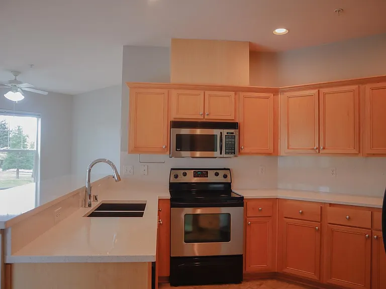 Kitchen with new quartz countertop, backsplash, sink and faucet. Stainless steel appliances (Fridge, Dishwasher, Stove/Oven, Microwave) installed.