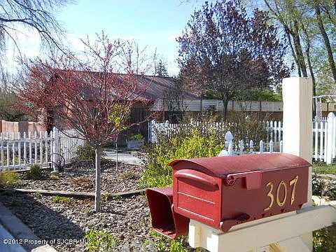 White picket fences, flowering trees, perennials, grass