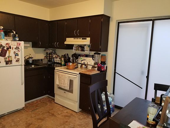 Kitchen with granite counter top and space for a small table. Slliders lead to fenced in yard.