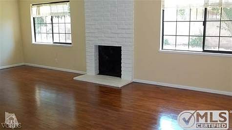 Large livingroom with floor-to-ceiling painted brick fireplace, ceiling fan with light fixture and newer windows.  Really nice with tons of decorating options!