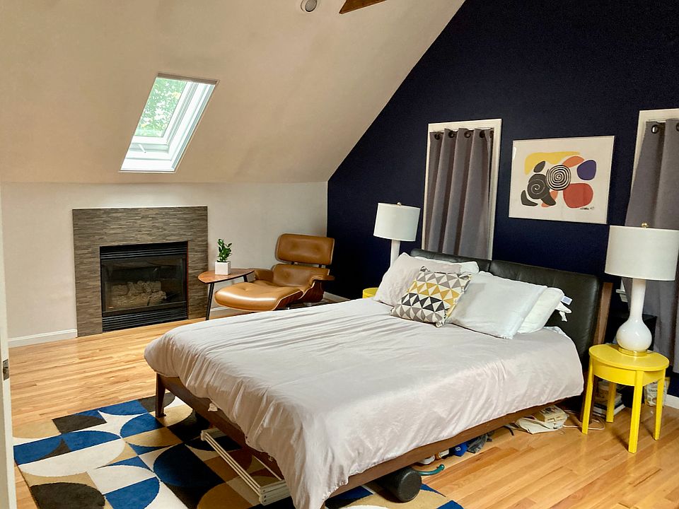 Lager bedroom, vaulted ceilings, skylights, electric fireplace. Accent wall can be painted white at renter's request.
