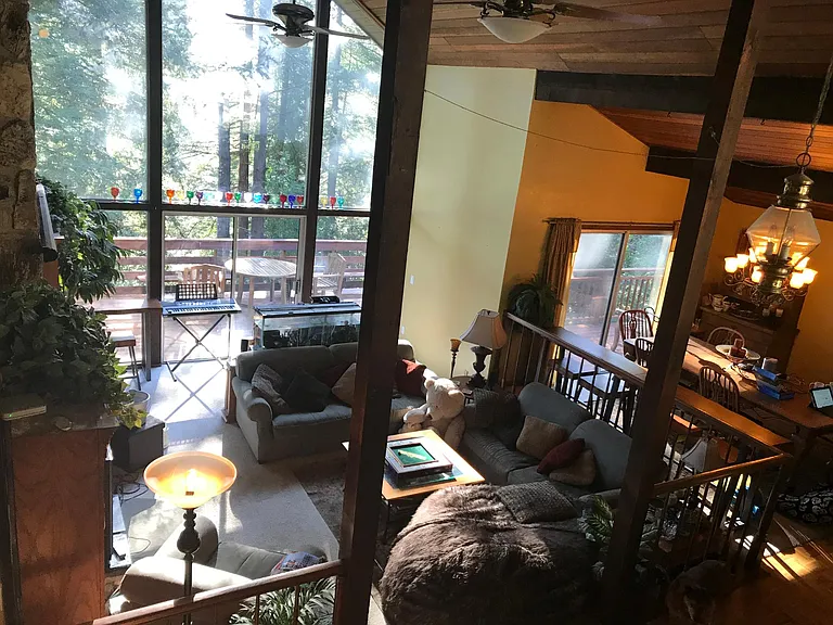 View from stair landing down to Living Room and Dining Room and deck beyond