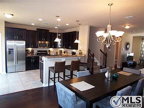 Lovely finishes such as dark wood floors, granite counters, stai