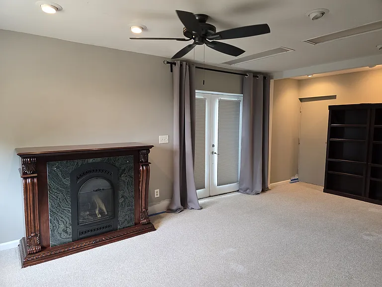 Living Space: Private French door entrance with custom room-darkening shades. Propane Fireplace and double bookcase, ceiling fan.