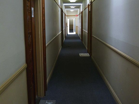 East/west corridor, approaching the unit. Note skylights and lighting.