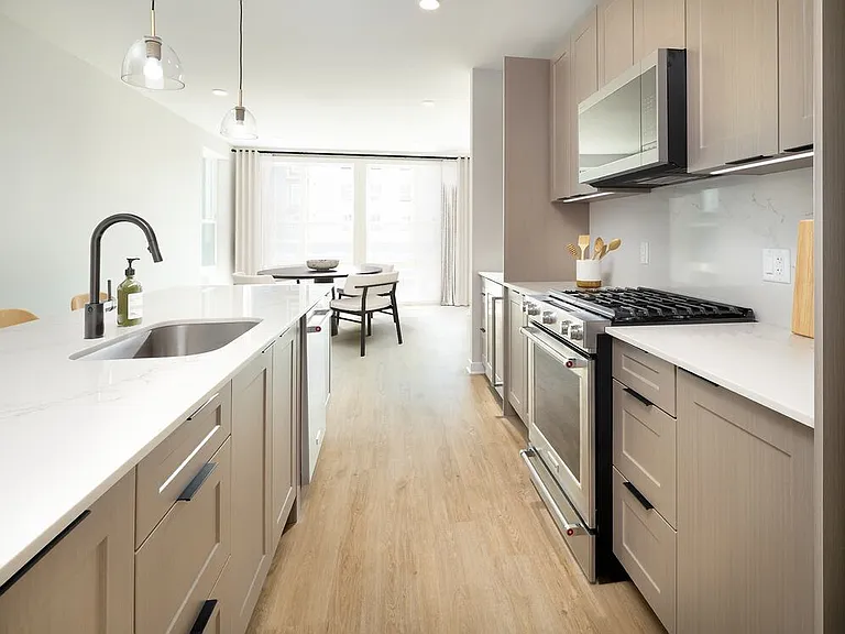 Signature Collection Kitchen with oak shaker cabinetry, marbled white quartz countertop and backsplash, and upgraded stainless steel appliances