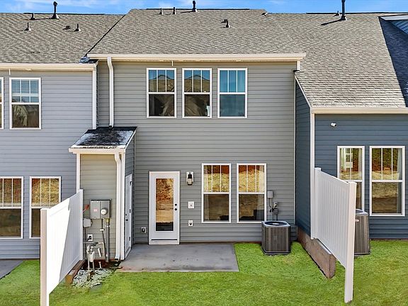 Townhome exterior with craftsman design, large windows, garage, two car parking pad, and blue siding