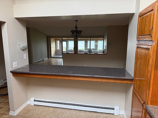 Kitchen counter/bar space looks into dining room area and living room beyond that