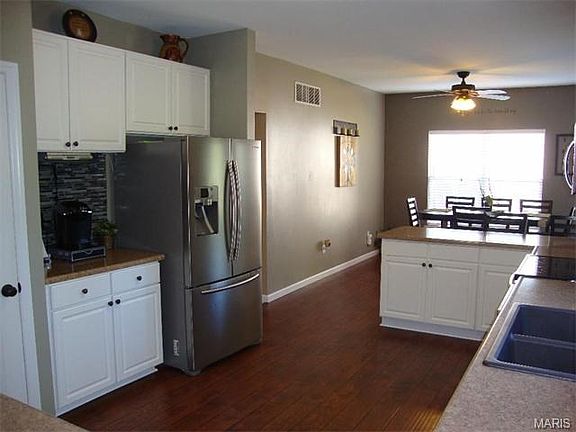 Extra cabinets by refrigerator are perfect for a coffee bar.
