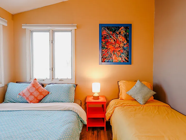 A room thoughtfully furnished with both a queen bed and a single bed, offering flexible sleeping arrangements for families or guests, maximizing comfort and space