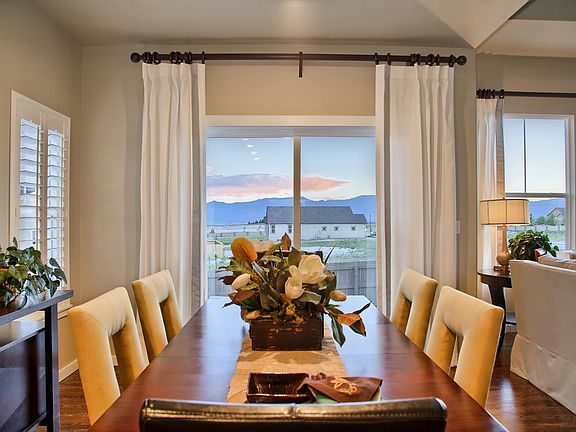 Dining room has a sliding door leading to the rear patio. Photo of model, home to be built