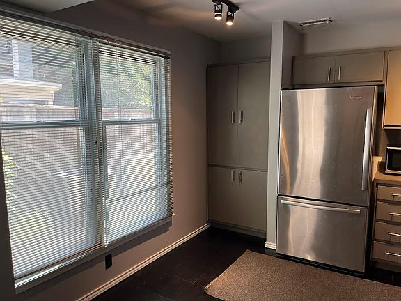 Breakfast nook off kitchen, with track lighting in front of windows facing south walkway, showing stainless steel refrigerator, with new ice maker.