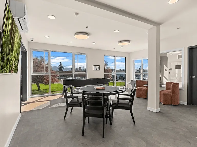 Sumner apartments with a resident lounge featuring game tables, modern seating, and large windows.
