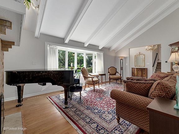 Large living room open with beamed ceiling and open to foyer