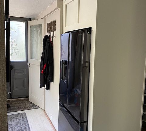 built-in fridge. behind it is the hideaway pantry