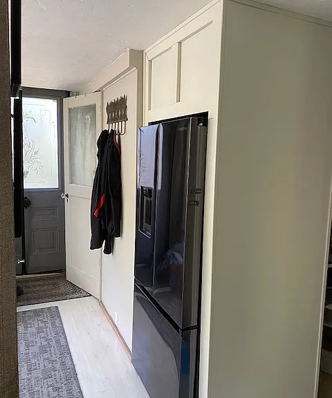 built-in fridge. behind it is the hideaway pantry