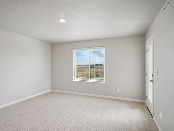 The master bedroom is spacious with a large window.