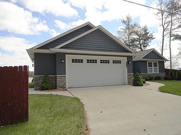 The attached garage with an automatic opener is 22 ft. deep by 28 ft. wide, and there's even a view of the lake from it!  The Wayne Dalton overhead door is 8 ft. by 18 ft. so nice and wide, and there's conveniently both hot and cold water faucets in the garage, as well as a Millikan man door.  To the left of the fence near the north lot line, there's an additional cement driveway that's 10 ft. by 60 ft. for extra parking!