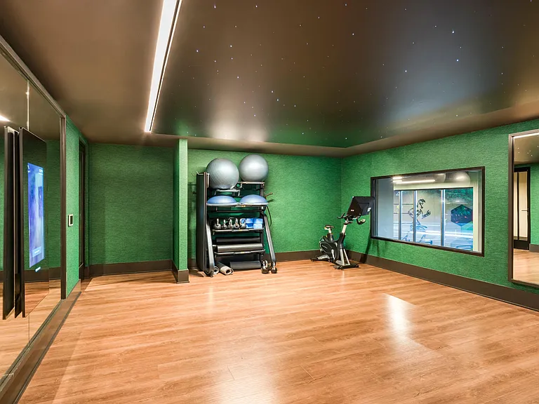 Movement studio with wood floors, mirrored walls, and fitness equipment designed for stretching, training, and mindful workouts.