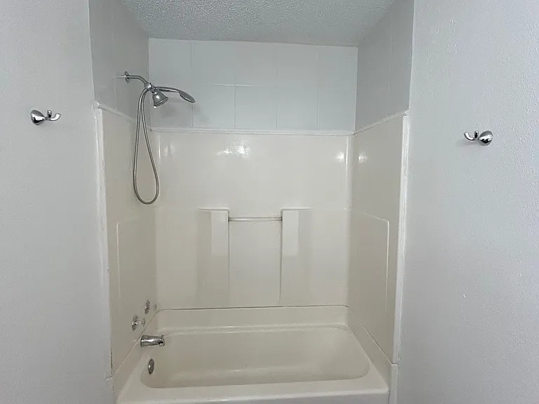 Resurfaced bathtub/shower surrounds with new hardware & fixtures.