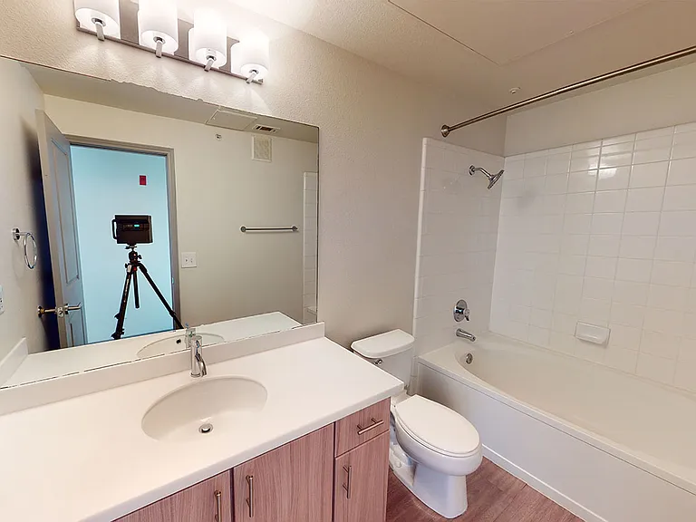 Apartment bathroom with wood-style flooring.