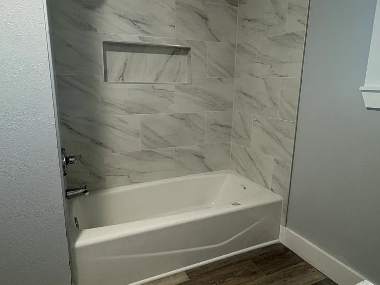 Shower and bath combo, bathroom also has a closet for storage