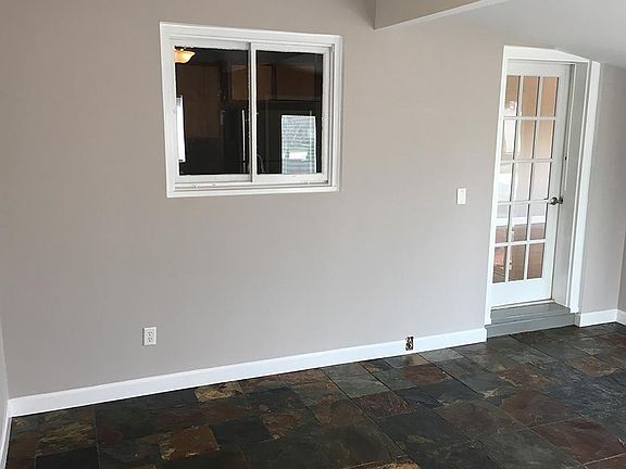 Bonus sunroom with slate tile floor and ceiling fan. Lots of