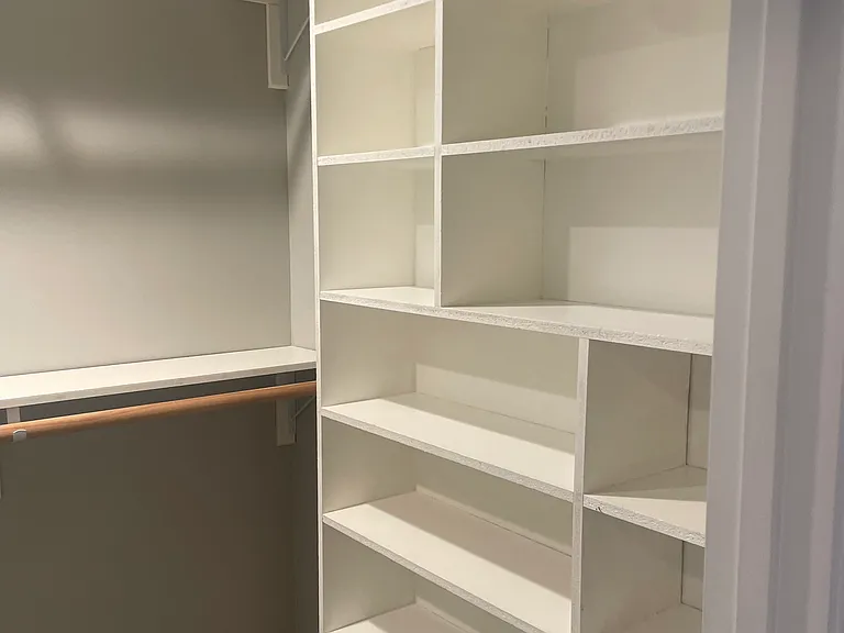 Walk in closet with lots of storage shelves.