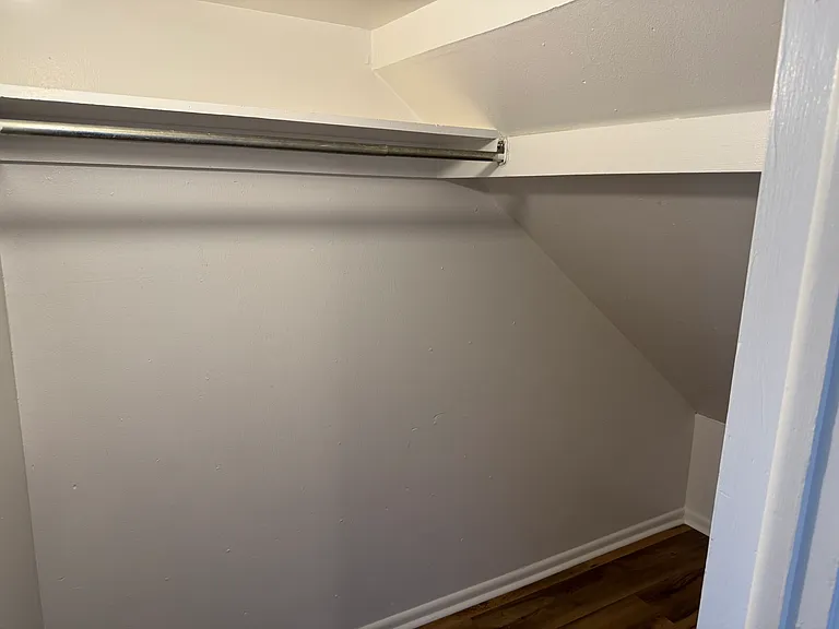 Hall closet extends under stairs for extra storage.