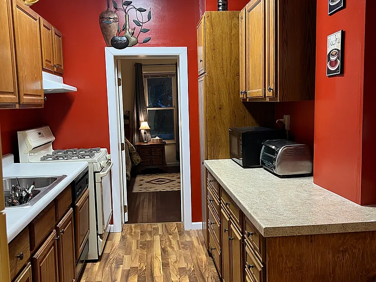 Walk-through kitchen, with dishwasher and gas stove, microwave, toaster oven, coffee maker