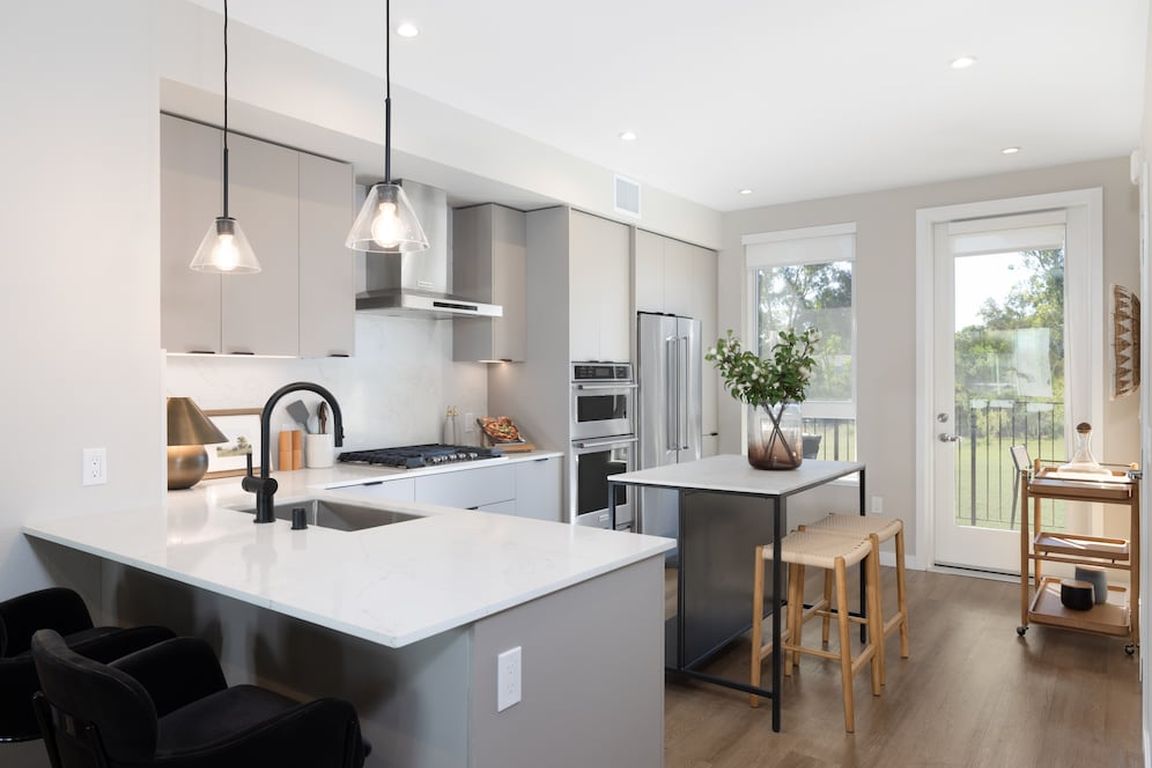Signature Collection I 3-Bedroom Townhome Kitchen with upgraded stainless steel appliances, pendant lighting, and undercabinet lighting