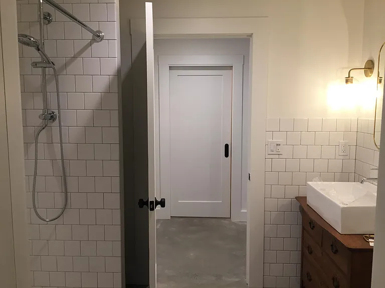 Looking through bathroom to hallway and pocket door to laundry.